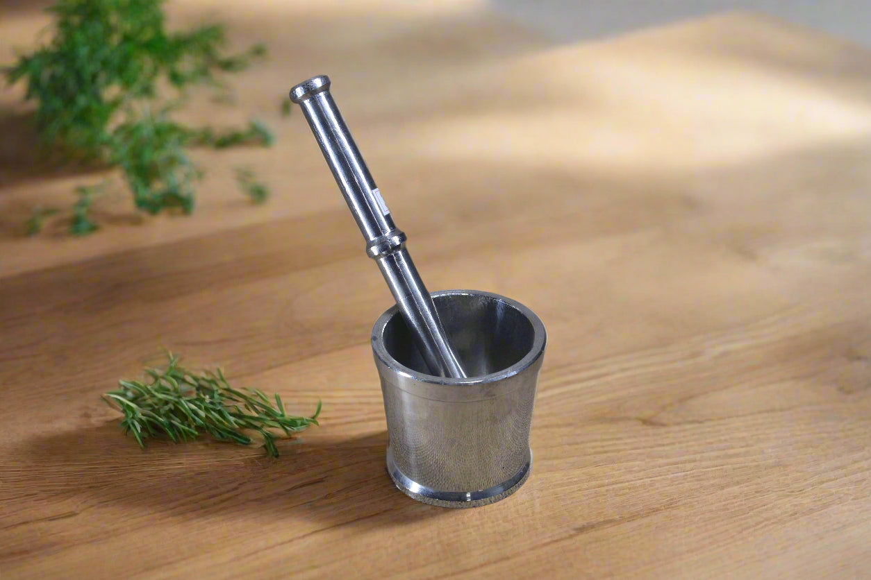 A stainless steel Ural with a long spout and a handle, placed on a textured fabric surface.