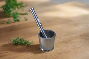 A stainless steel Ural with a long spout and a handle, placed on a textured fabric surface.