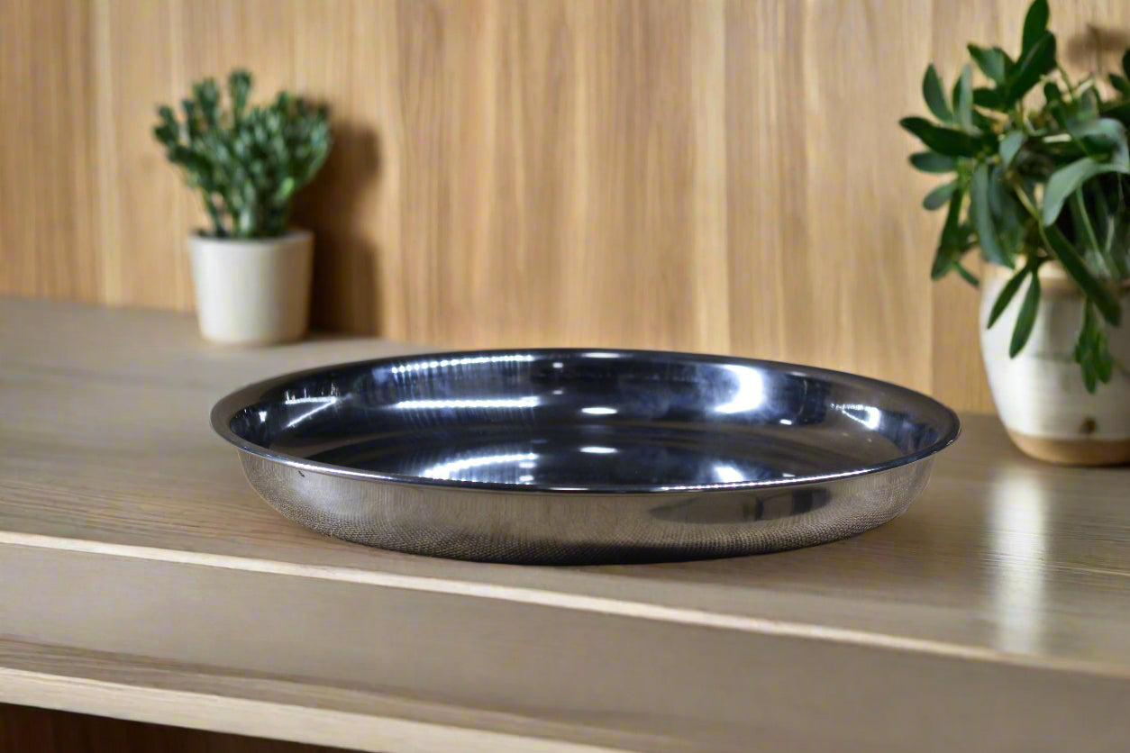 A stainless steel plate placed on a textured fabric surface.