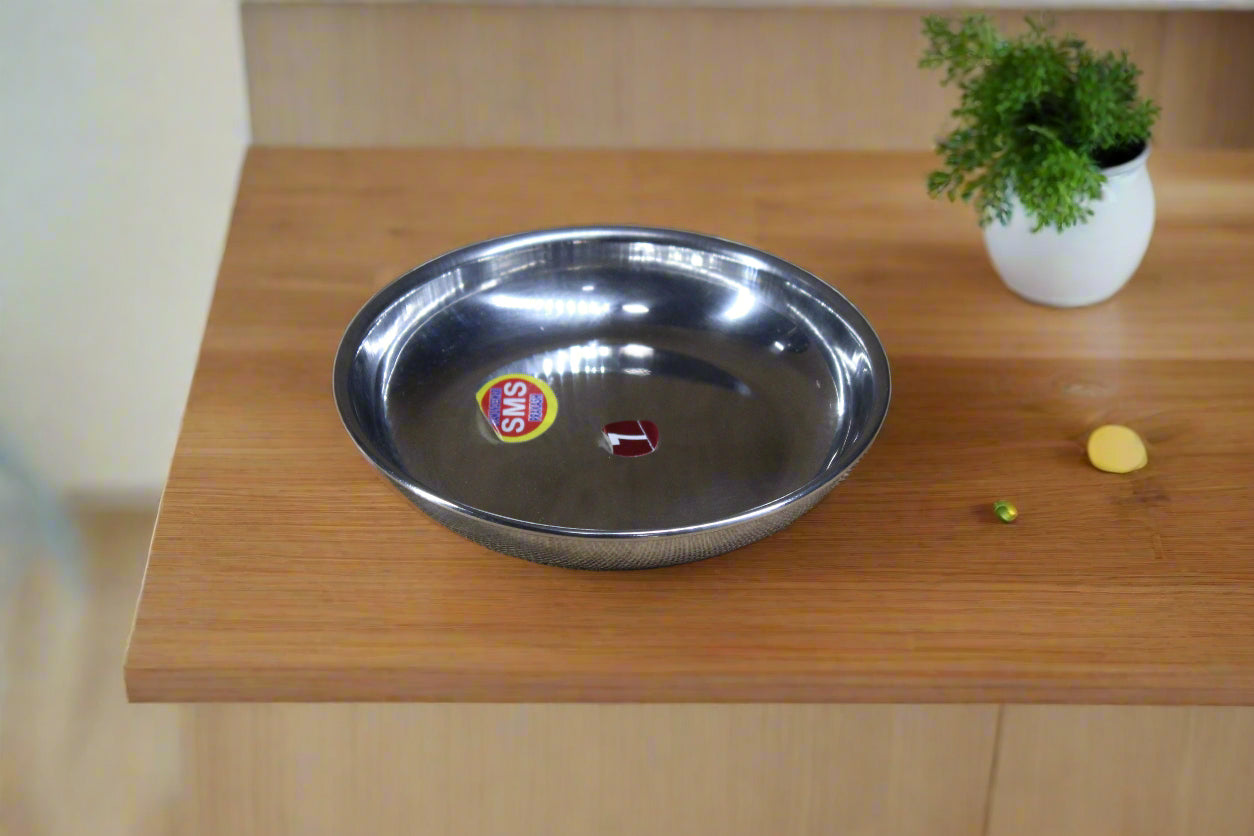 A stainless steel small plate with a reflective metallic finish on a textured beige background.