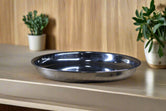 A stainless steel plate placed on a textured fabric surface.