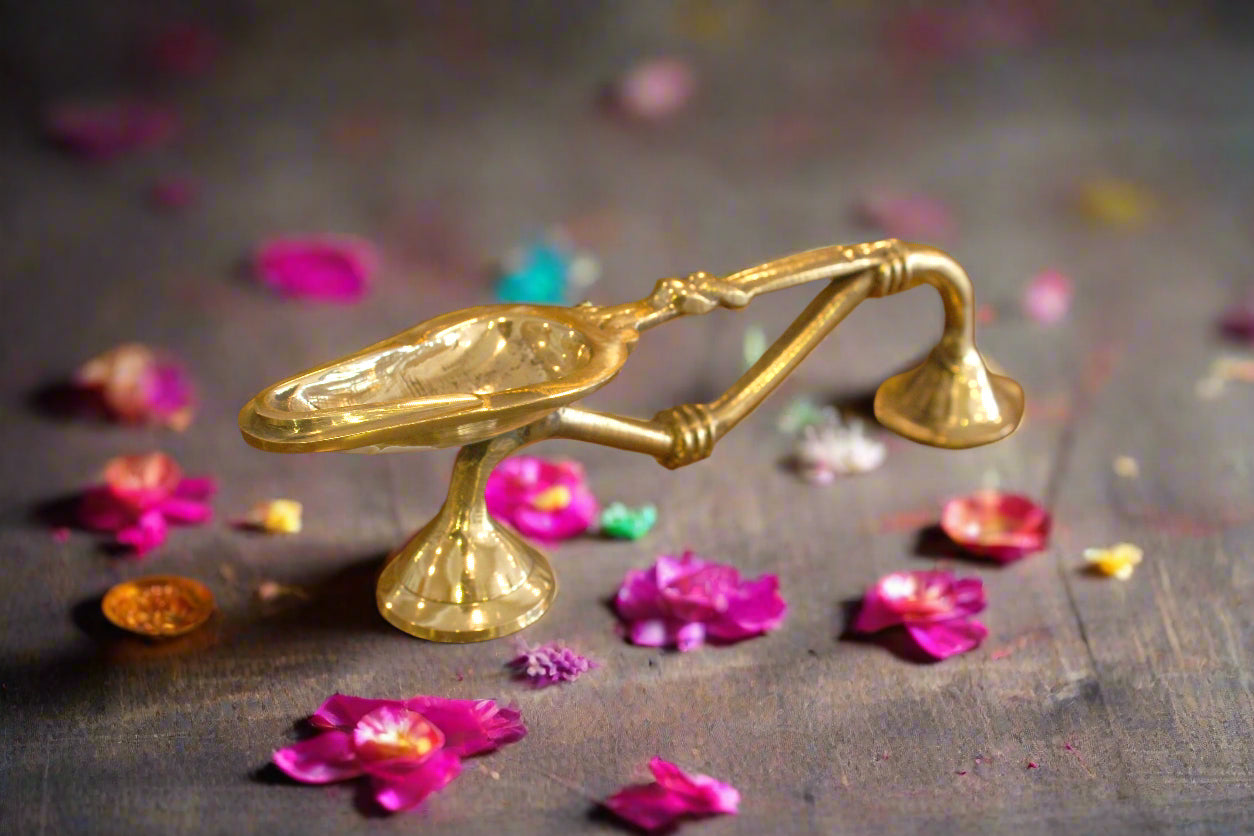 Gold candle snuffer on a wooden surface
