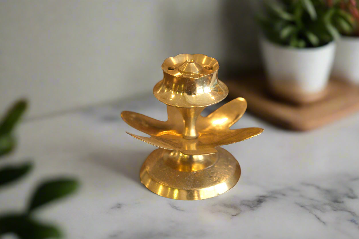 Gold-colored decorative item on a reflective surface with a blurred background